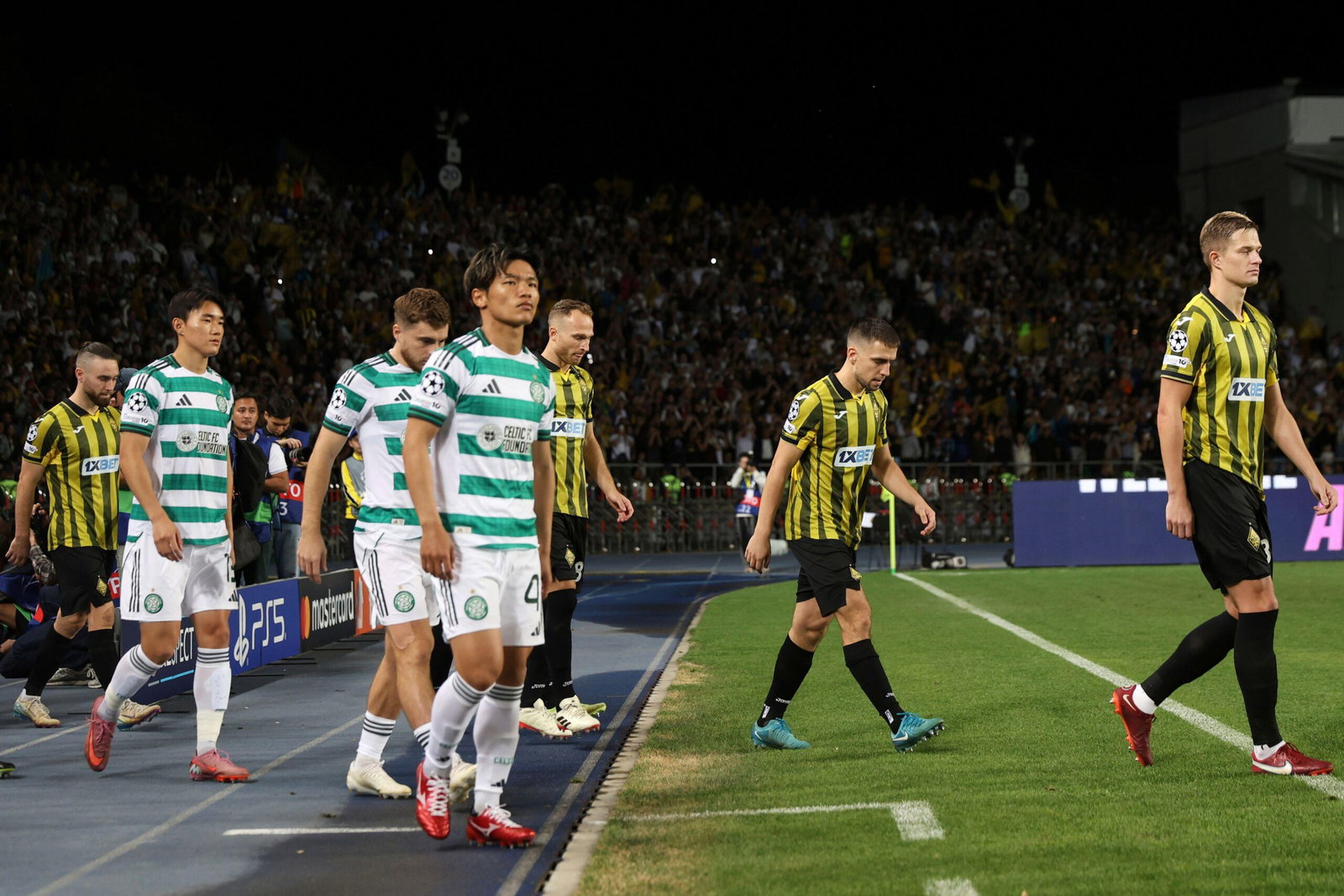 Players enter the pitch before the Champions League playoff second leg soccer match between Kairat and Celtic at Ortalyk stadium in Almaty, Kazakhstan, Tuesday, Aug. 26, 2025. (AP Photo/Alikhan Sariyev)